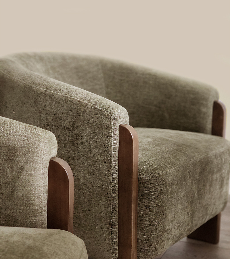 Réalisations en design d’intérieur à Mirabel : fauteuils contemporains en tissu texturé vert olive et structure en bois, illustrant le choix de mobilier et de matériaux par Atelier Ancrage.